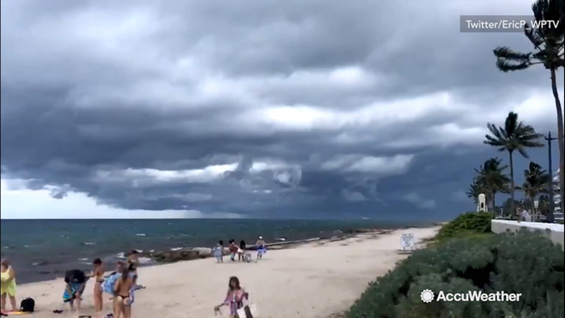 Beach goers at the Municipal Beach of Palm Beach, Florida flee the scene as they see ominous looking storm clouds start to roll in on July 8.