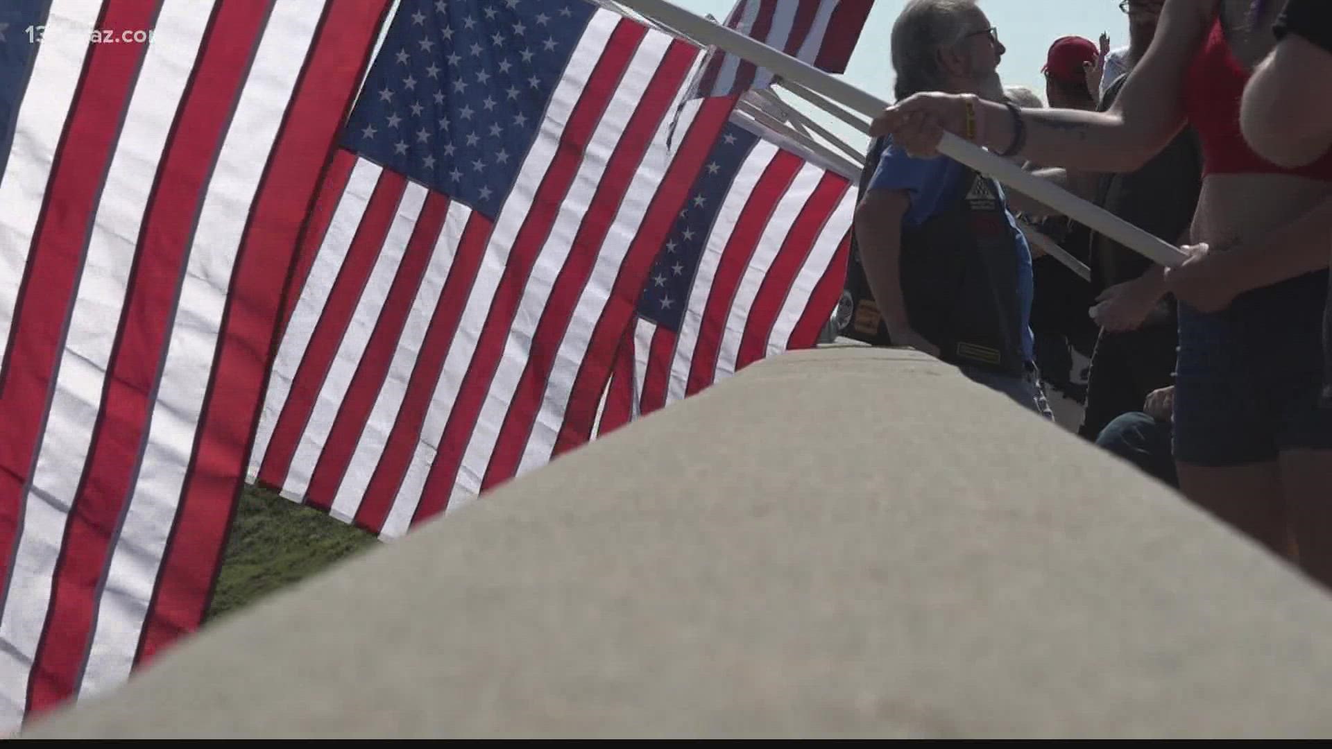 The group gathered atop the Russell Parkway bridge and waved several American flags in support of service members.