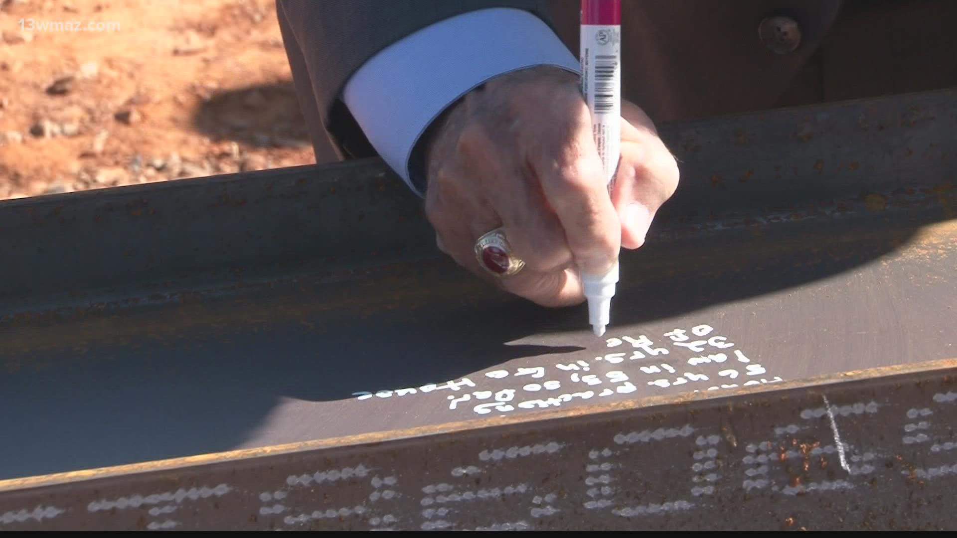 In Perry, public officials and others gathered to celebrate the topping at the new State Expansion building site.