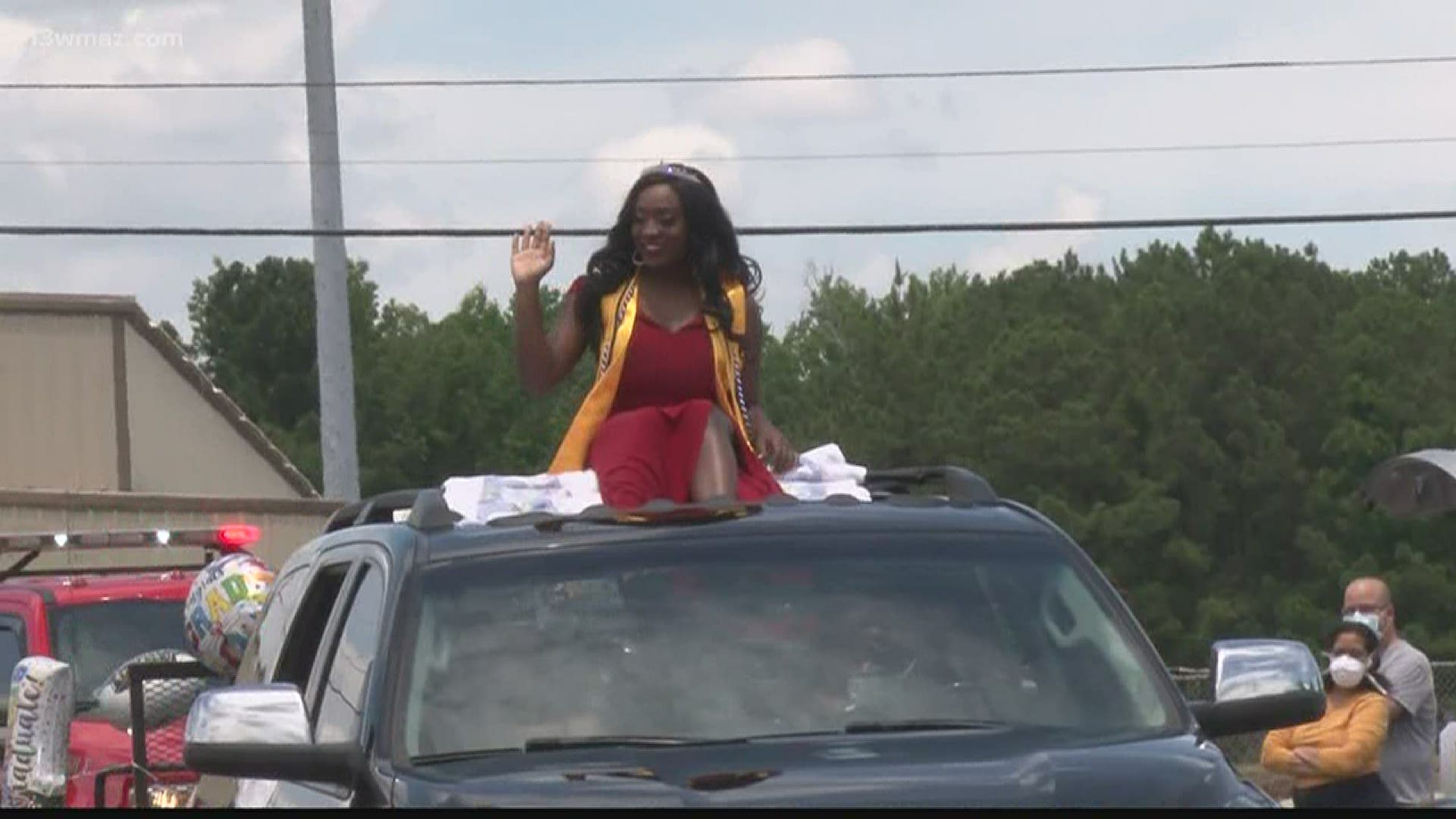 Senior Ally Henry was escorted through a strip mall parking lot in Byron Sunday in front of dozens of family and friends cheering her on.