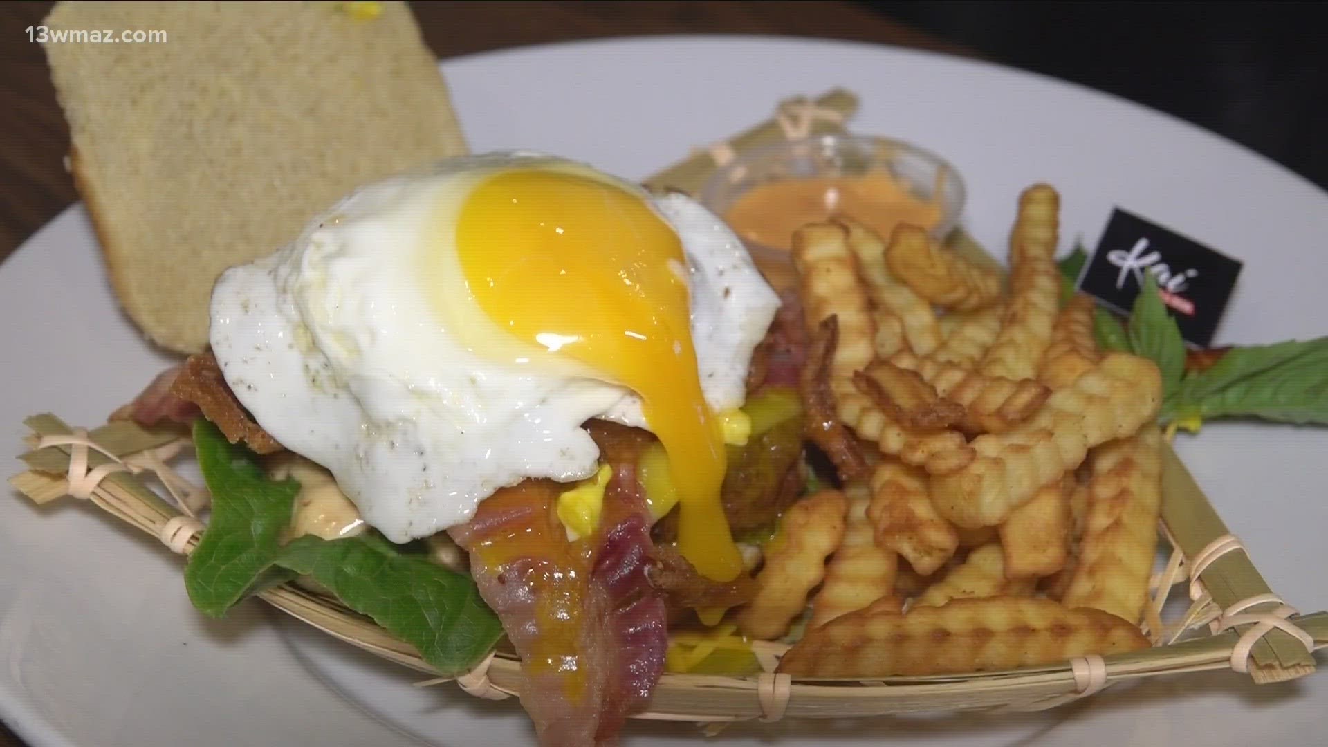 It features a steak patty with lettuce, pepper jack cheese, bacon, fried onion strings, and a fried egg.