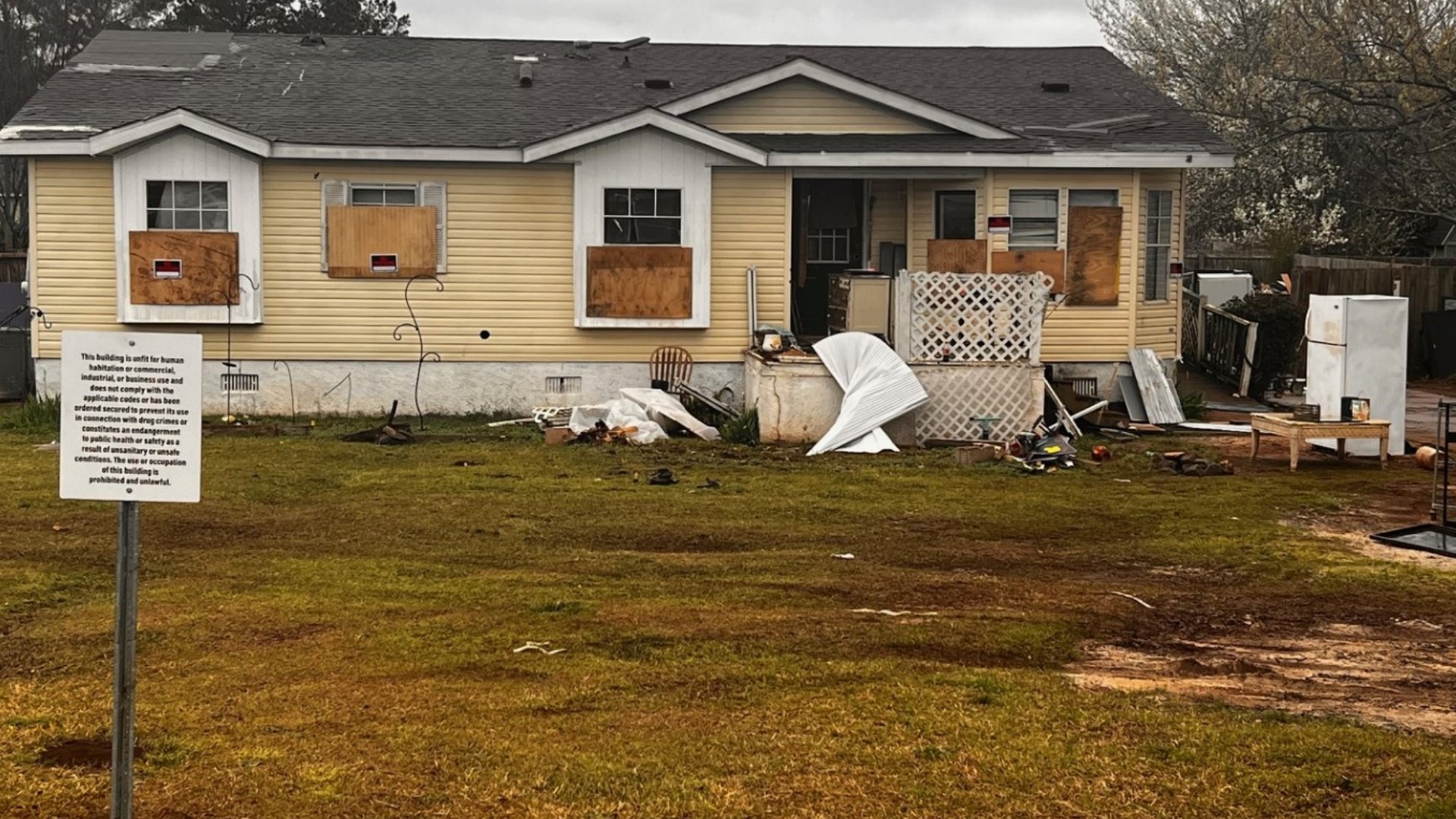 The backyard also has trash dumped everywhere, including broken-down cars, piles of garbage, human waste, and other debris.