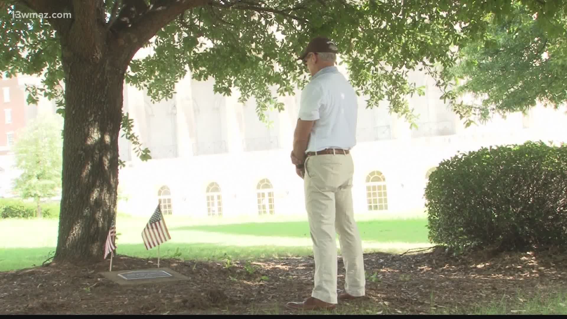 Andy Greenway places flags at Major Cole Hogan's markers throughout Macon on 9/11 and Memorial Day.